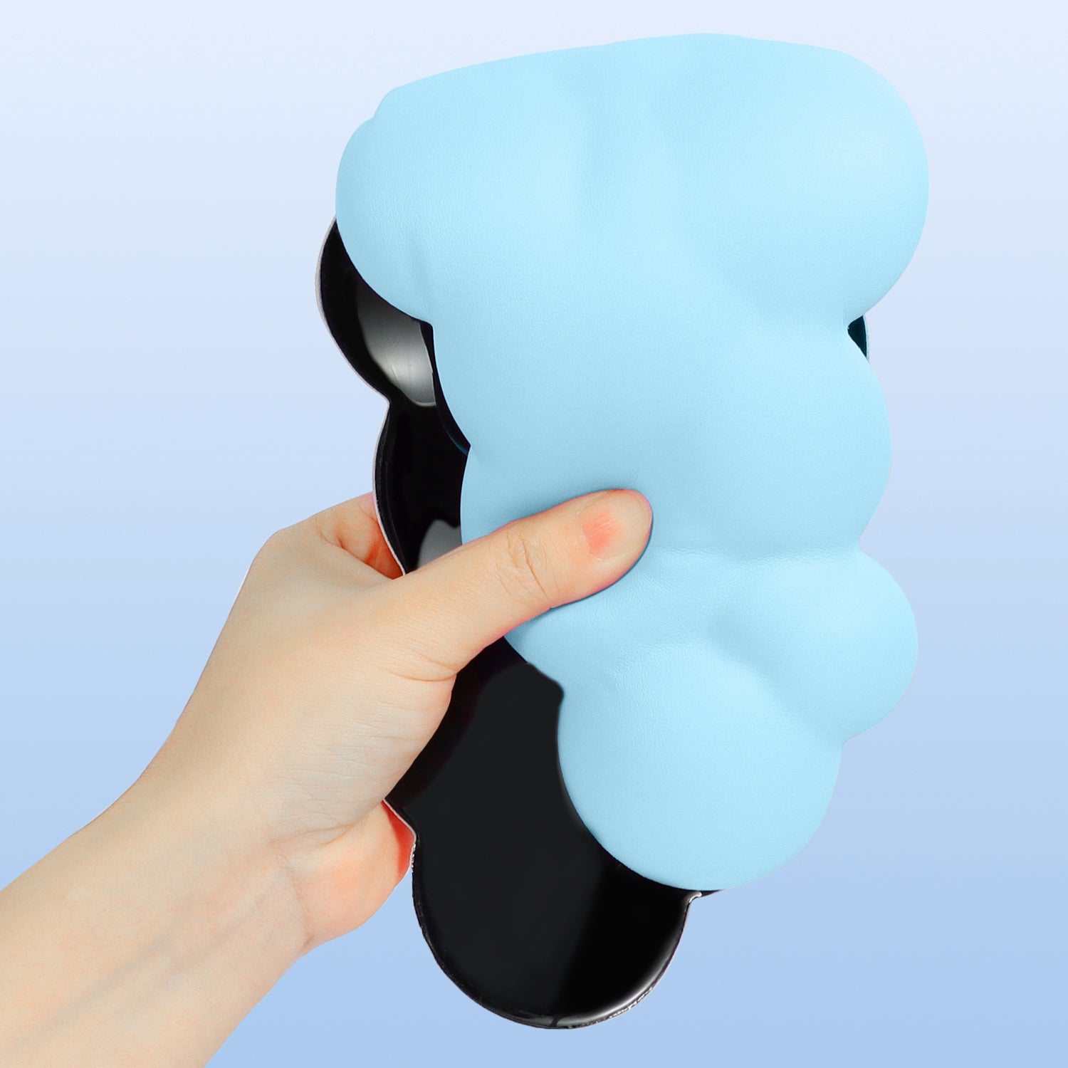 Light blue cloud-shaped wrist rest held in hand with ergonomic design.