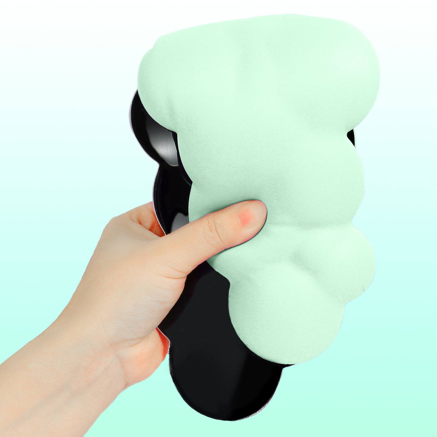 Mint green cloud-shaped ergonomic wrist rest held in hand showing soft foam and anti-slip base.