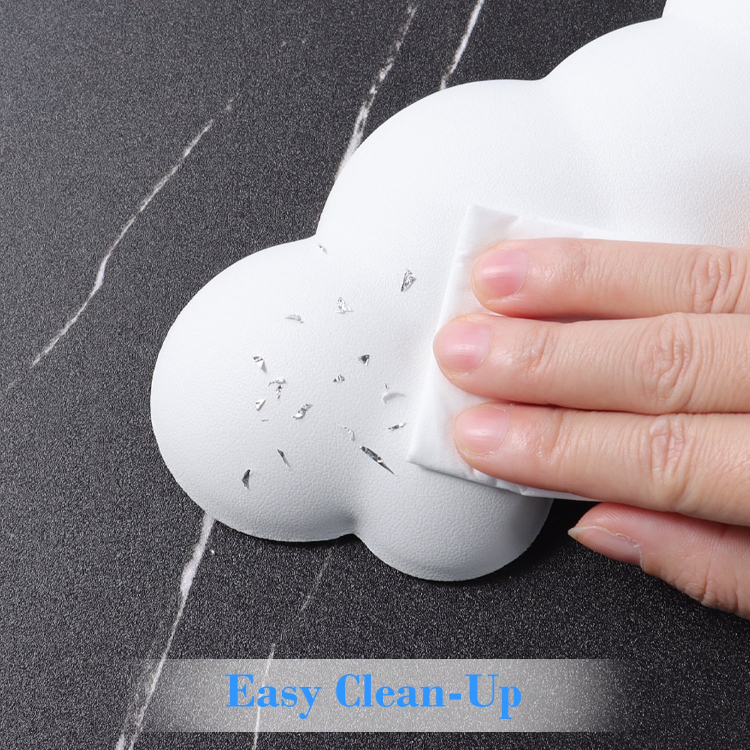 Hand cleaning a cloud-shaped wrist rest with easy wipe surface