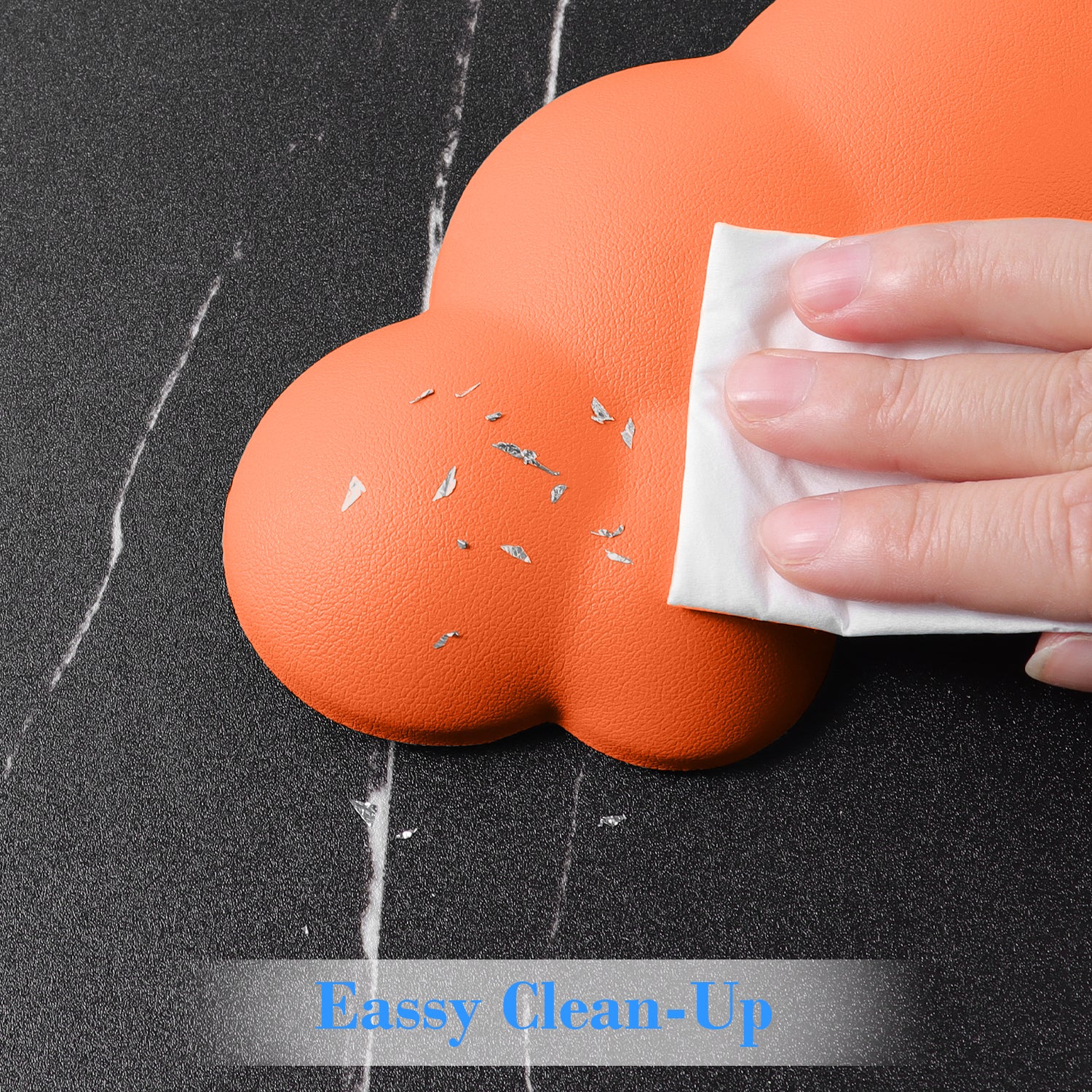 Hand wiping orange cloud-shaped wrist rest for easy cleaning.