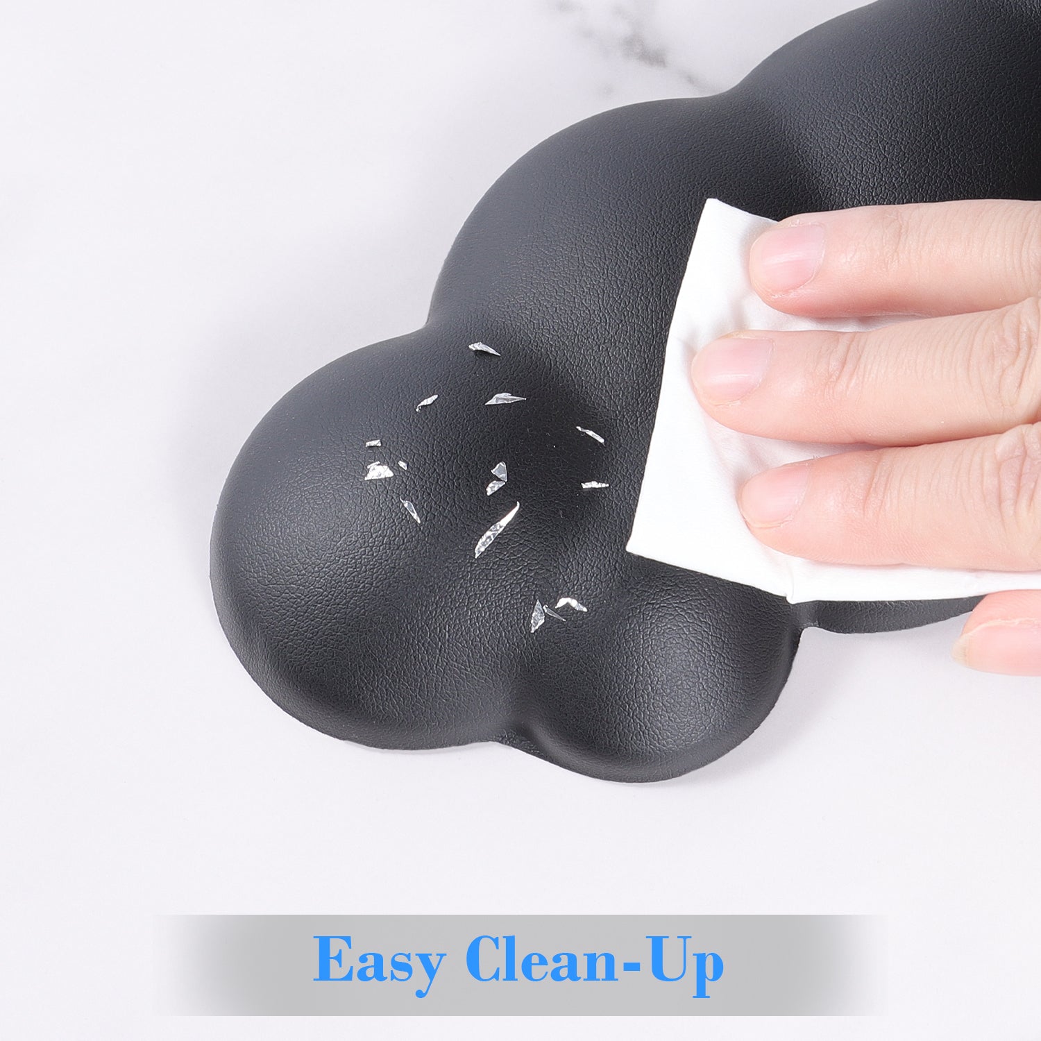 Hand wiping black cloud-shaped wrist rest for easy cleaning.