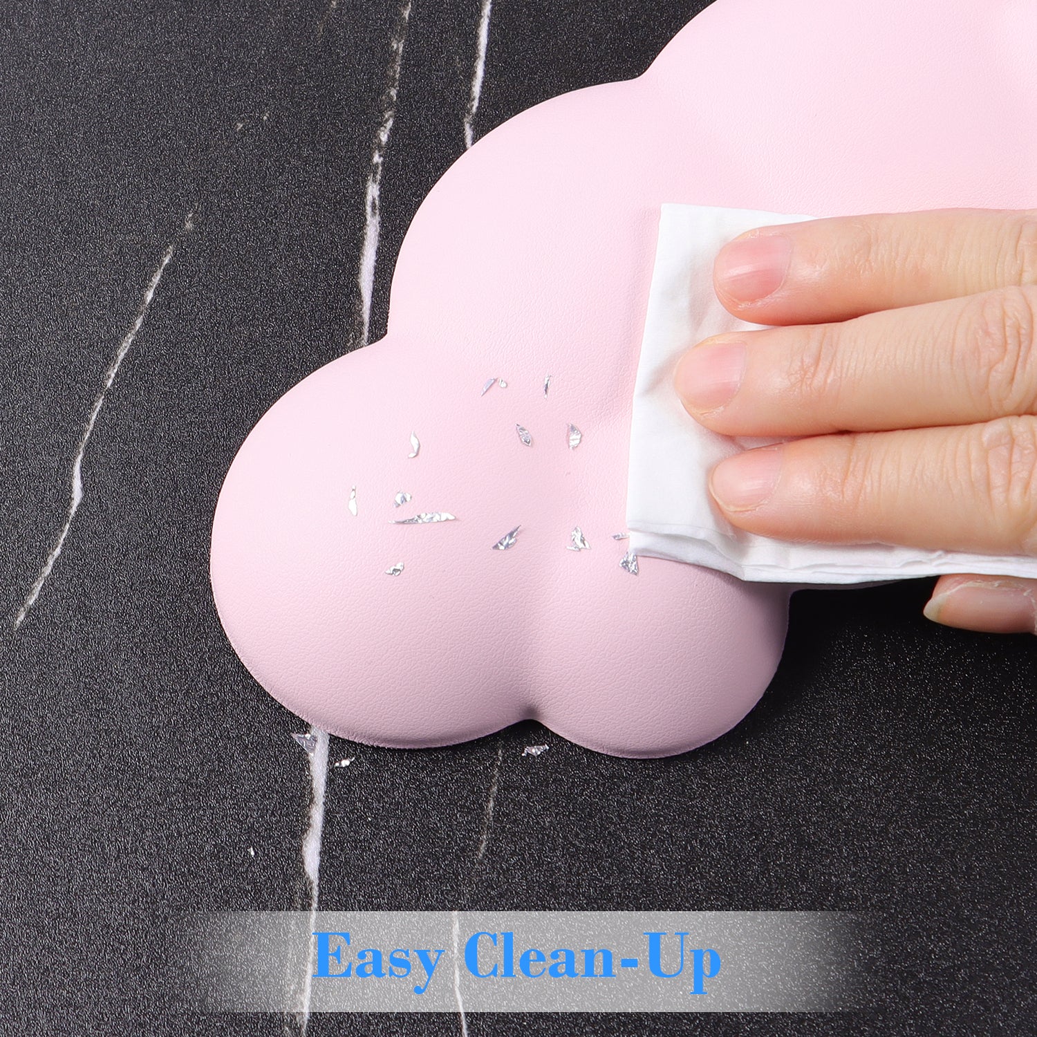 Hand wiping pink cloud-shaped wrist rest for easy cleaning.