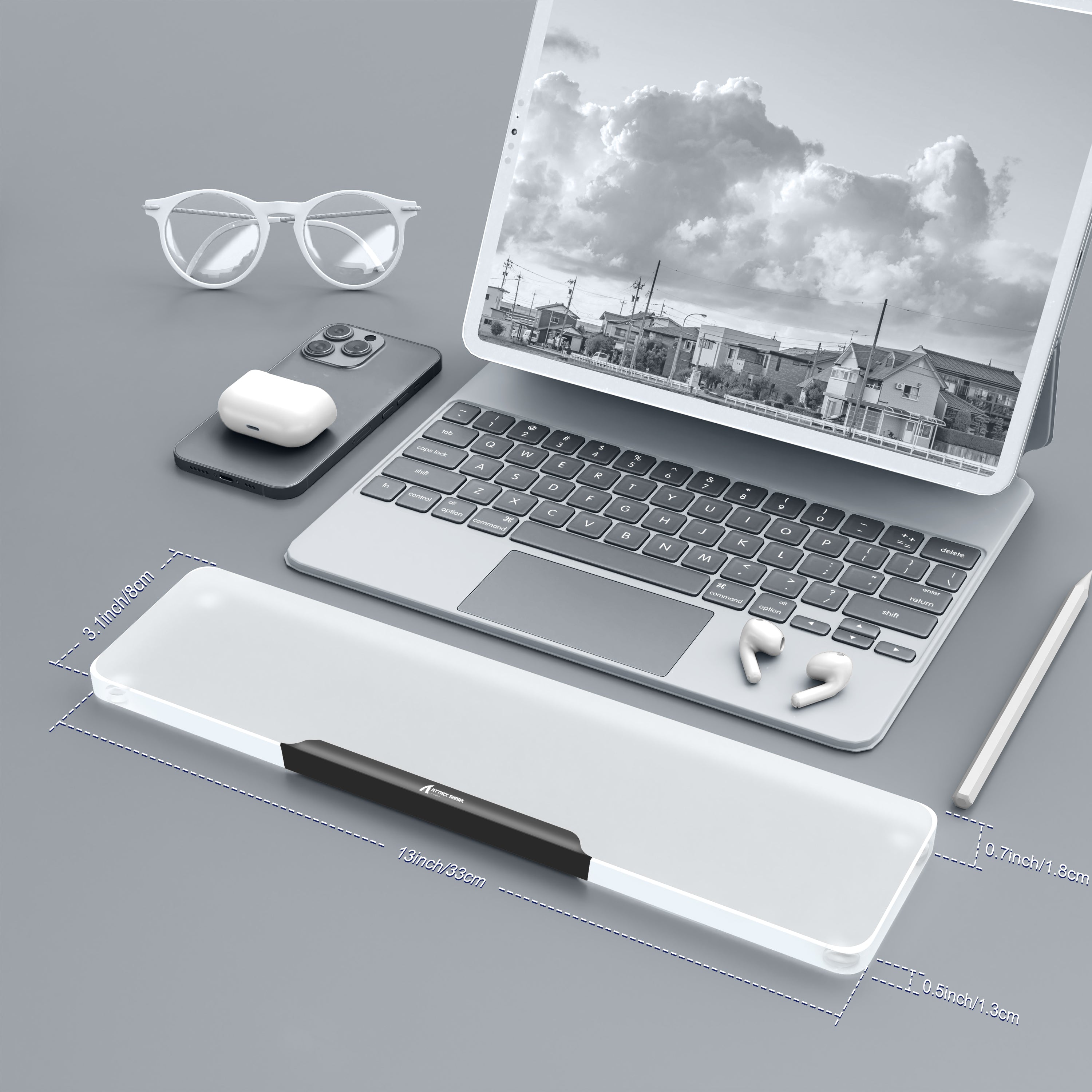 Translucent acrylic wrist rest on a desk with laptop and accessories for ergonomic support.