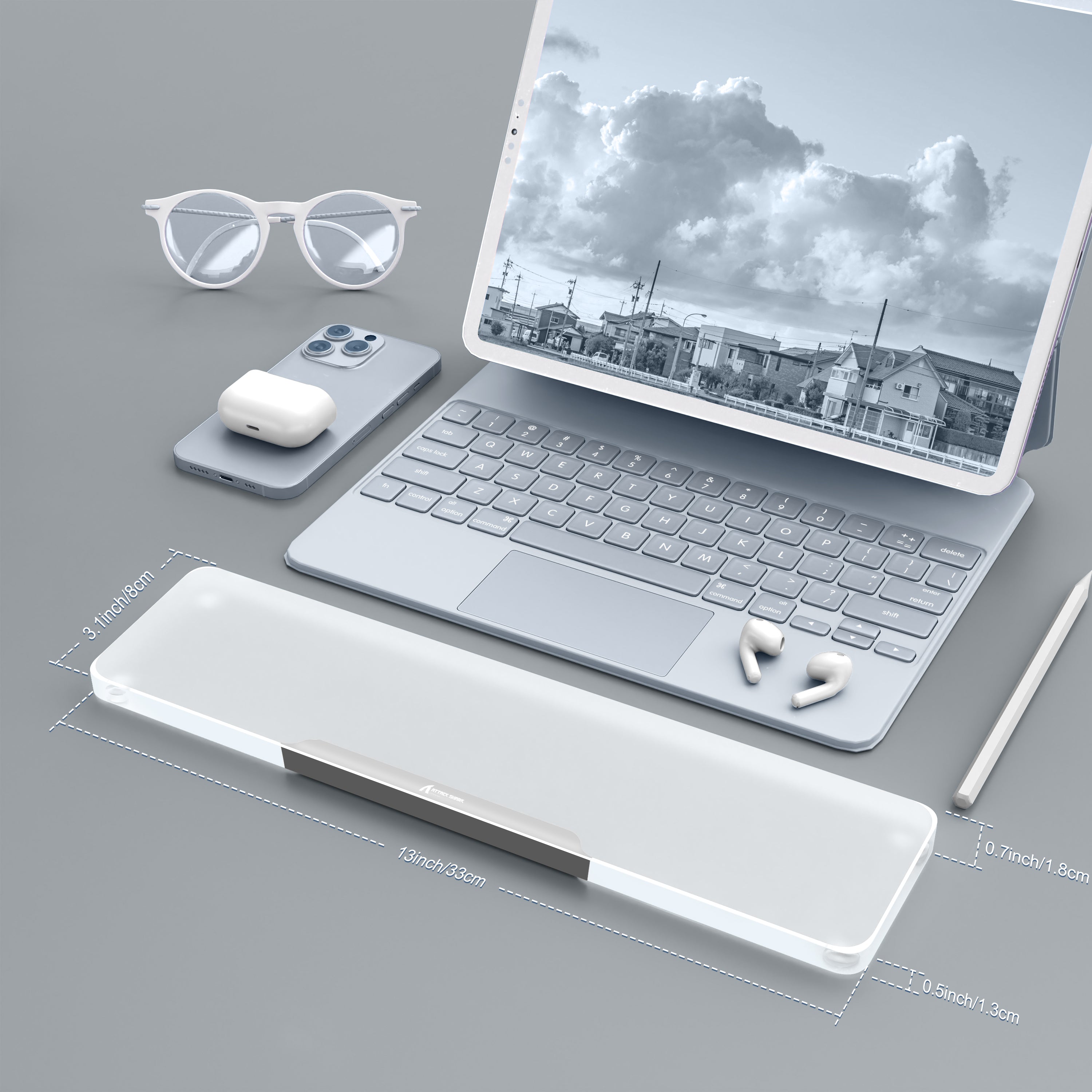 Translucent acrylic wrist rest with aluminum edge beside a laptop and accessories.