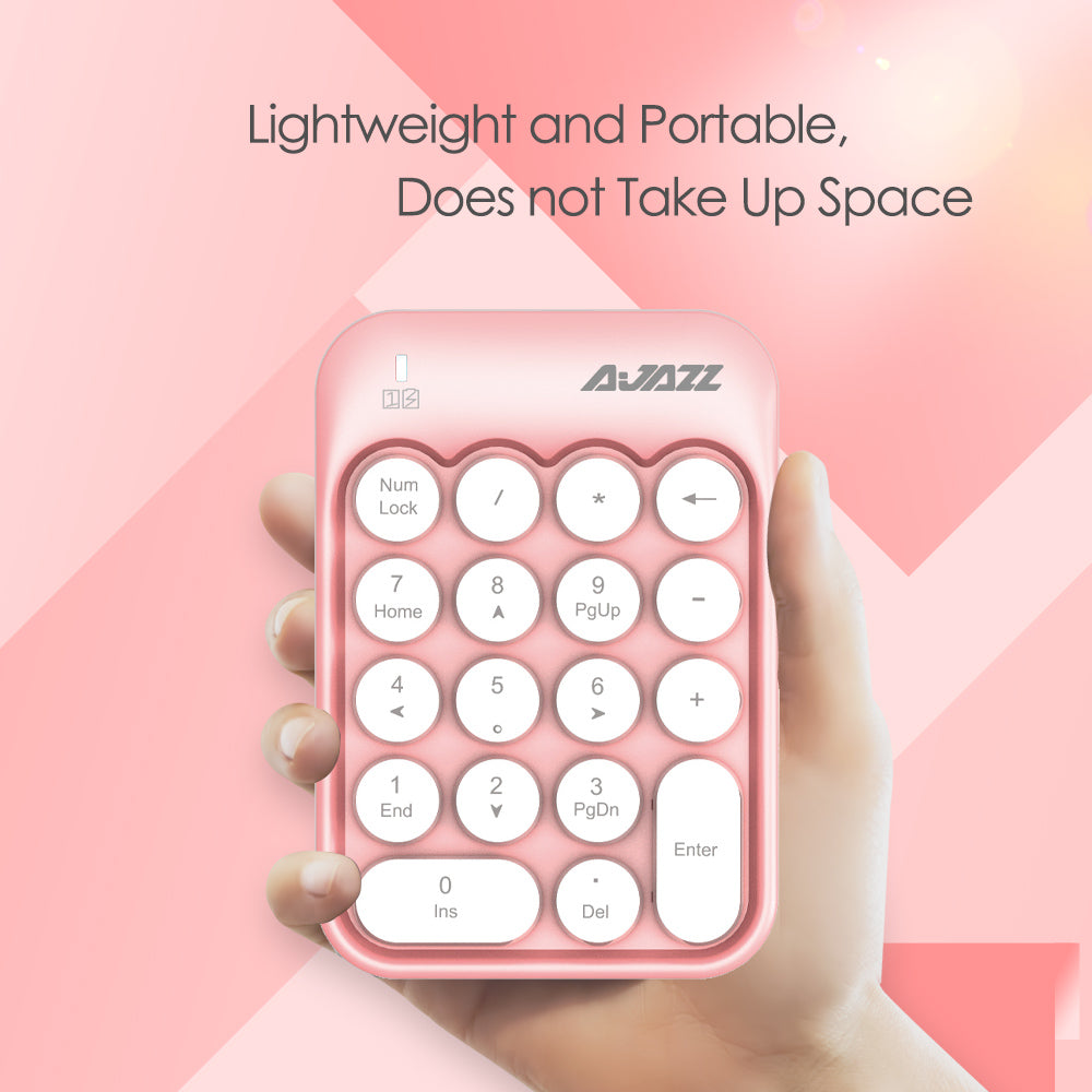 Hand holding pink wireless numeric keypad with rounded keys, emphasizing portability.