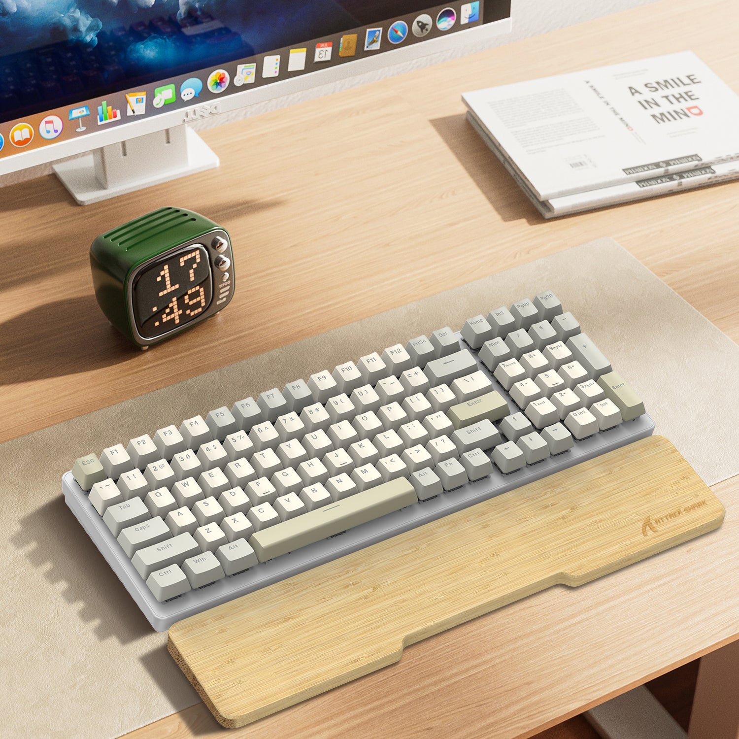 Bamboo wrist rest with compact cream and gray mechanical keyboard on wooden desk.