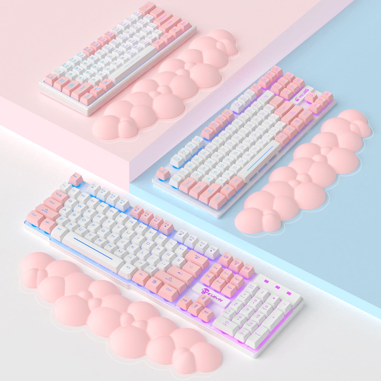 Cloud-shaped pink wrist rest next to two pastel-themed mechanical keyboards.